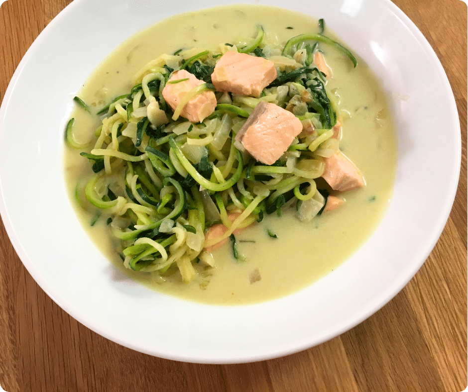 Zoodles mit Lachs in cremiger Sauce – serviert auf einem weißen Teller als gesundes Familiengericht