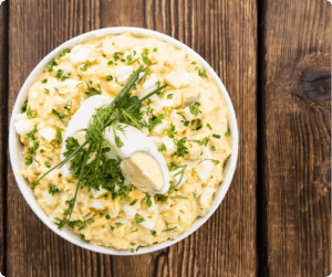 Eiersalat in einer weißen Schüssel auf Holztisch