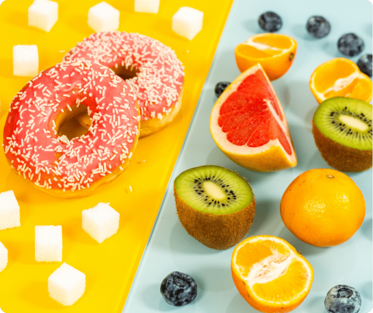 Donuts, Zuckerwürfel und Obst auf bunten Hintergrund